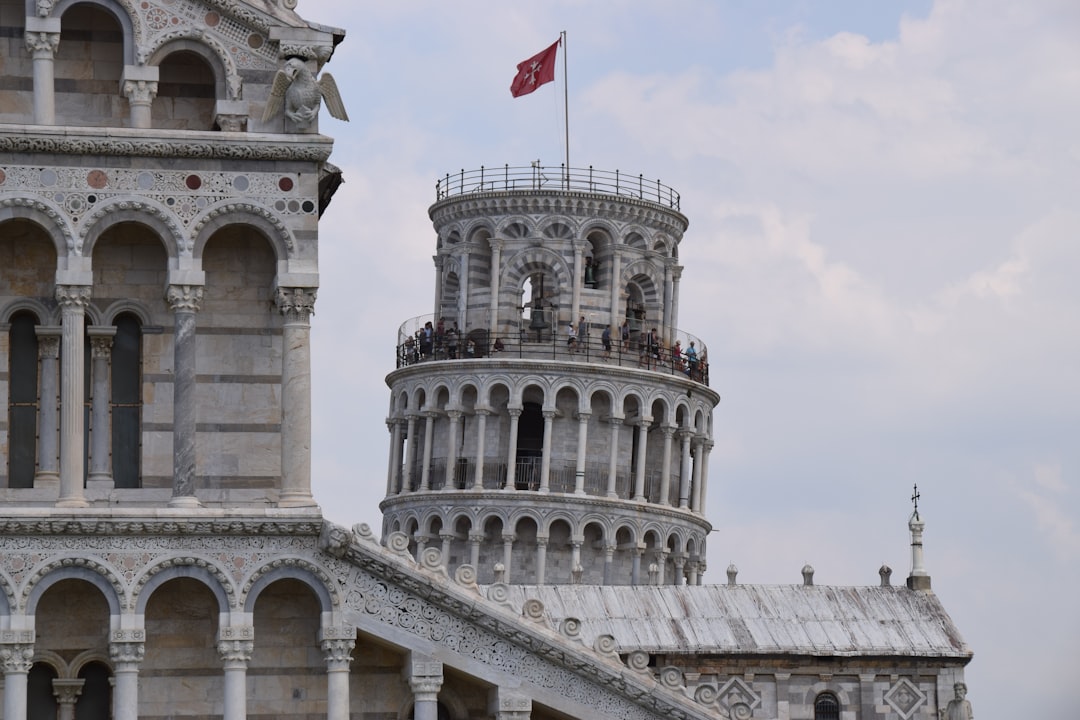 a tall tower with a flag on top of it, Leaning tower of pisa