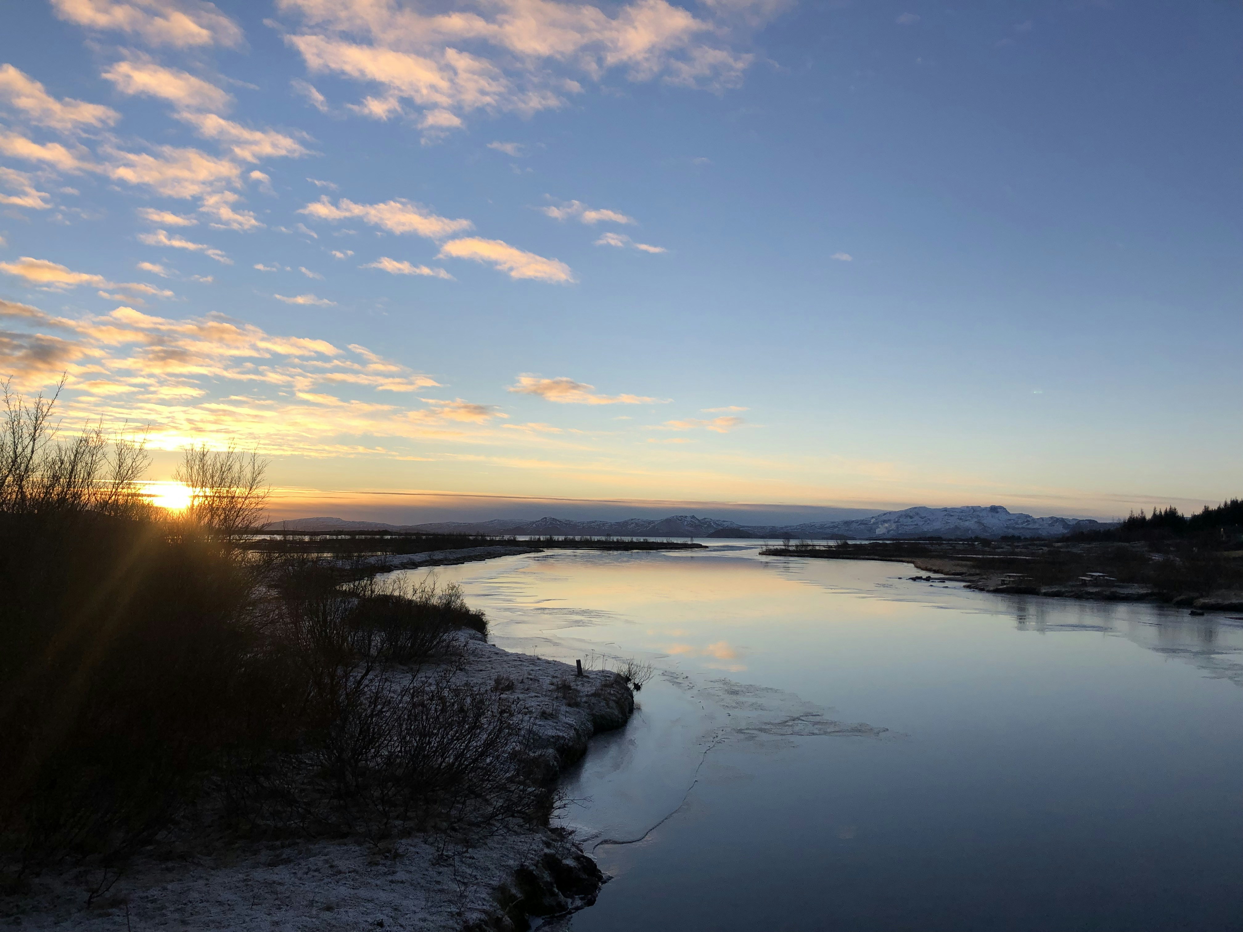 the sun is setting over a body of water