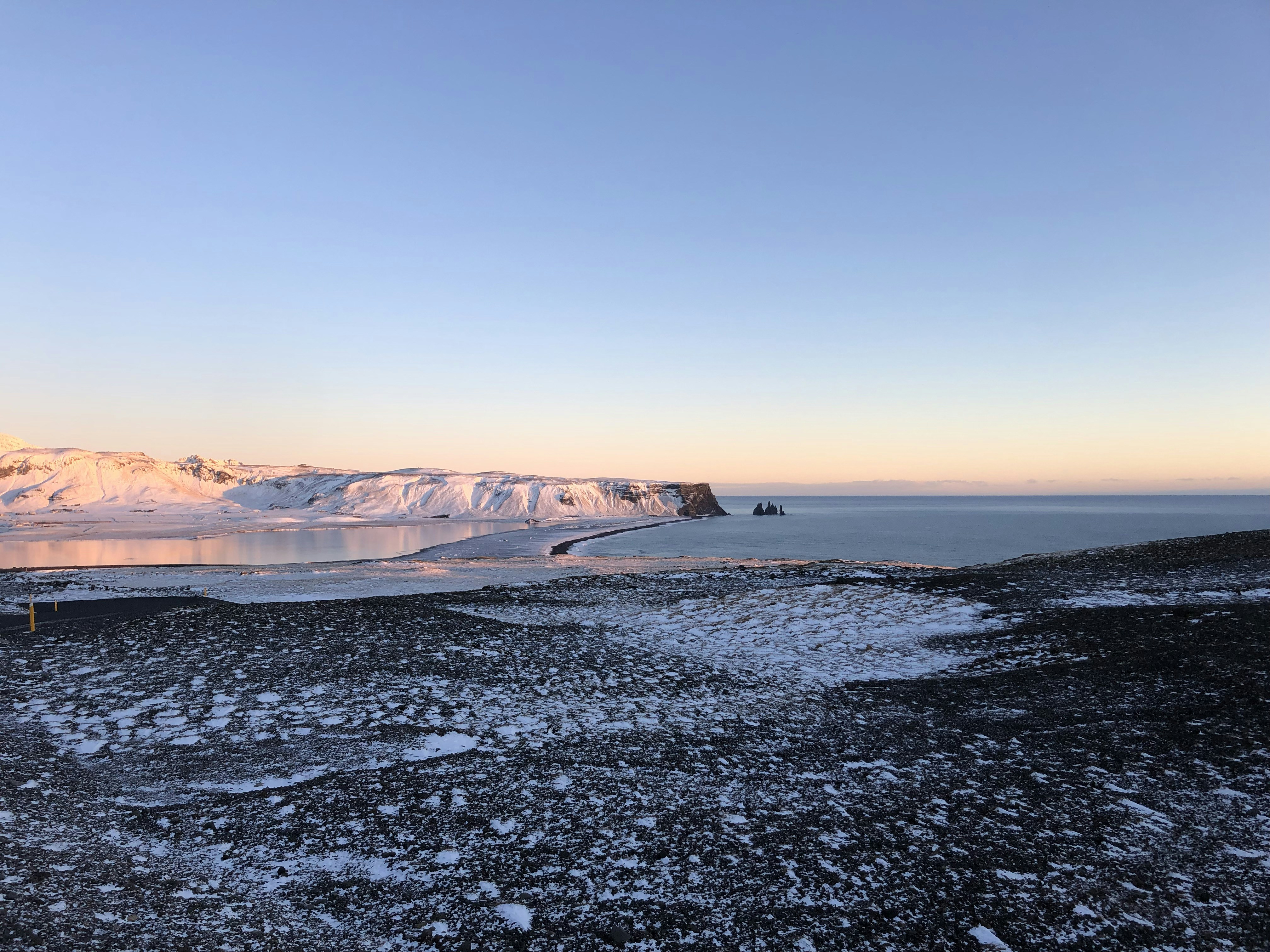 a large body of water surrounded by snow covered mountains