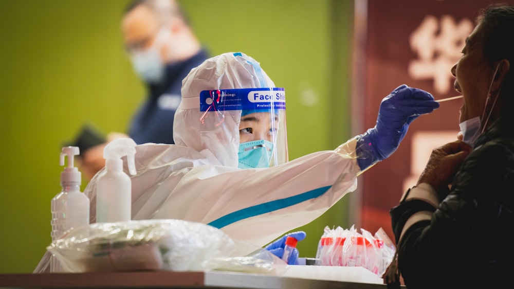 uma pessoa vestindo um traje de proteção e segurando uma escova de dentes