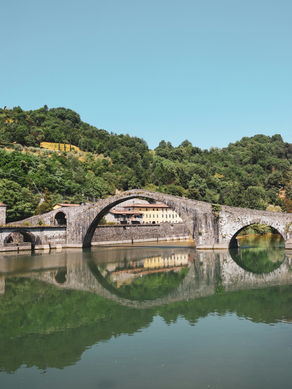 a bridge over a body of water with a mountain in the background