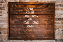 a wooden sign that says don't count the days make the days count