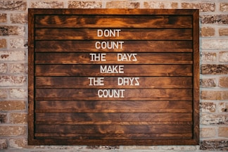 a wooden sign that says don't count the days make the days count