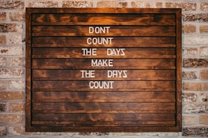 a wooden sign that says don't count the days make the days count