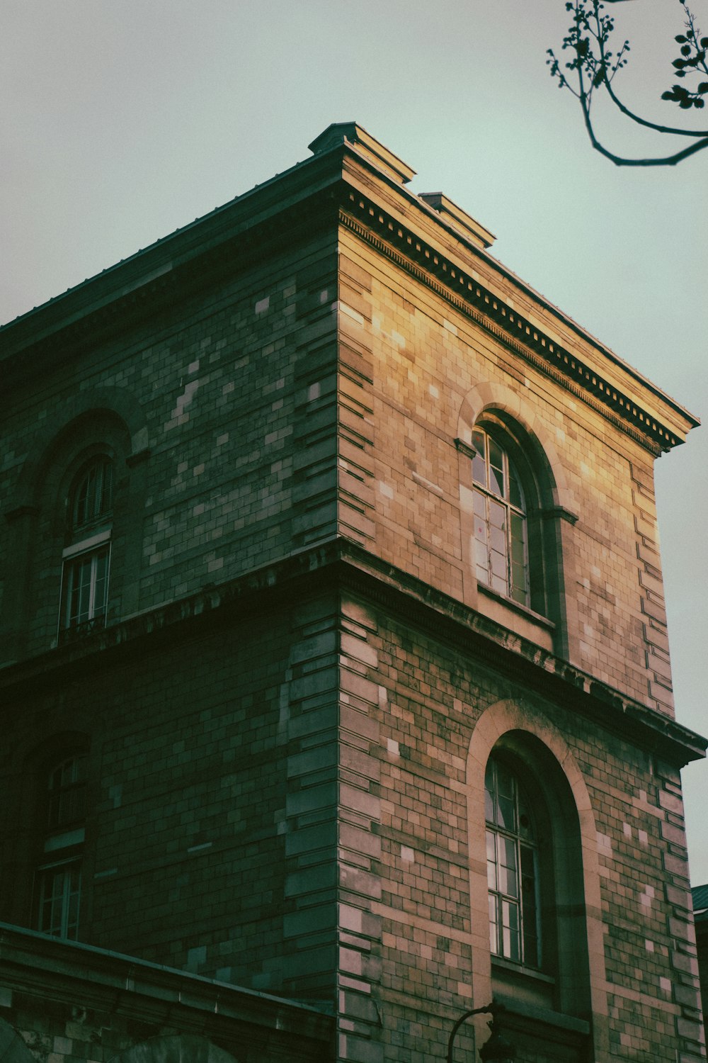 a tall brick building with a clock on it's side