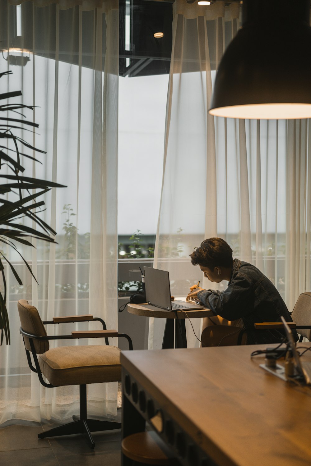 a man sitting at a table working on a laptop