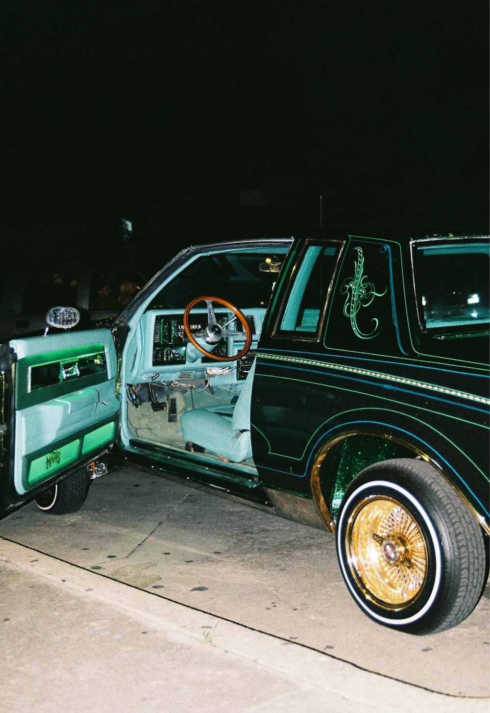 a green truck with a gold rim parked on the side of the road