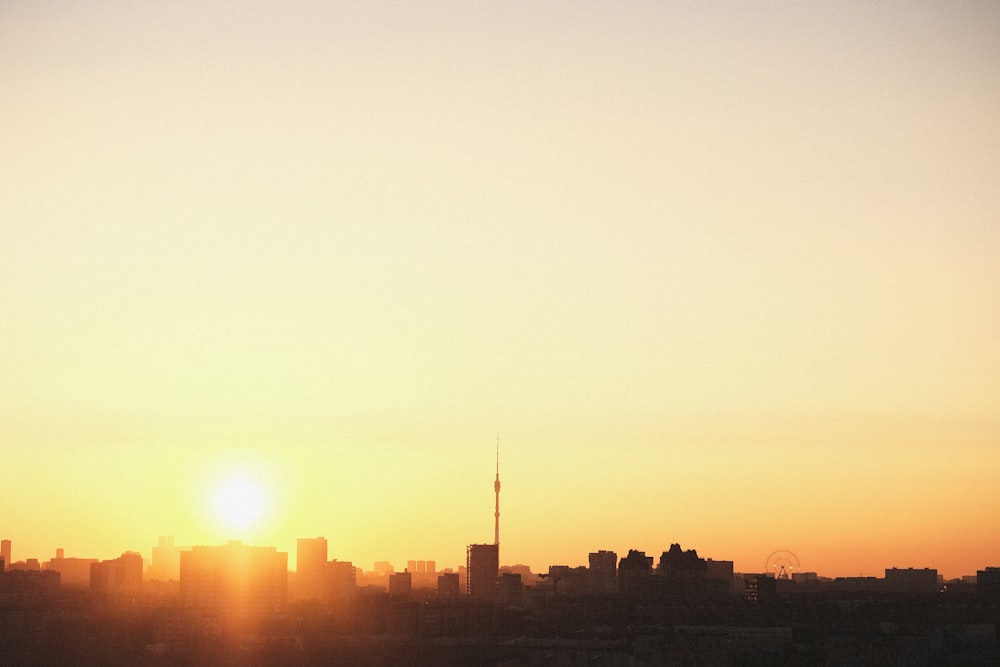 a plane flying over a city at sunset