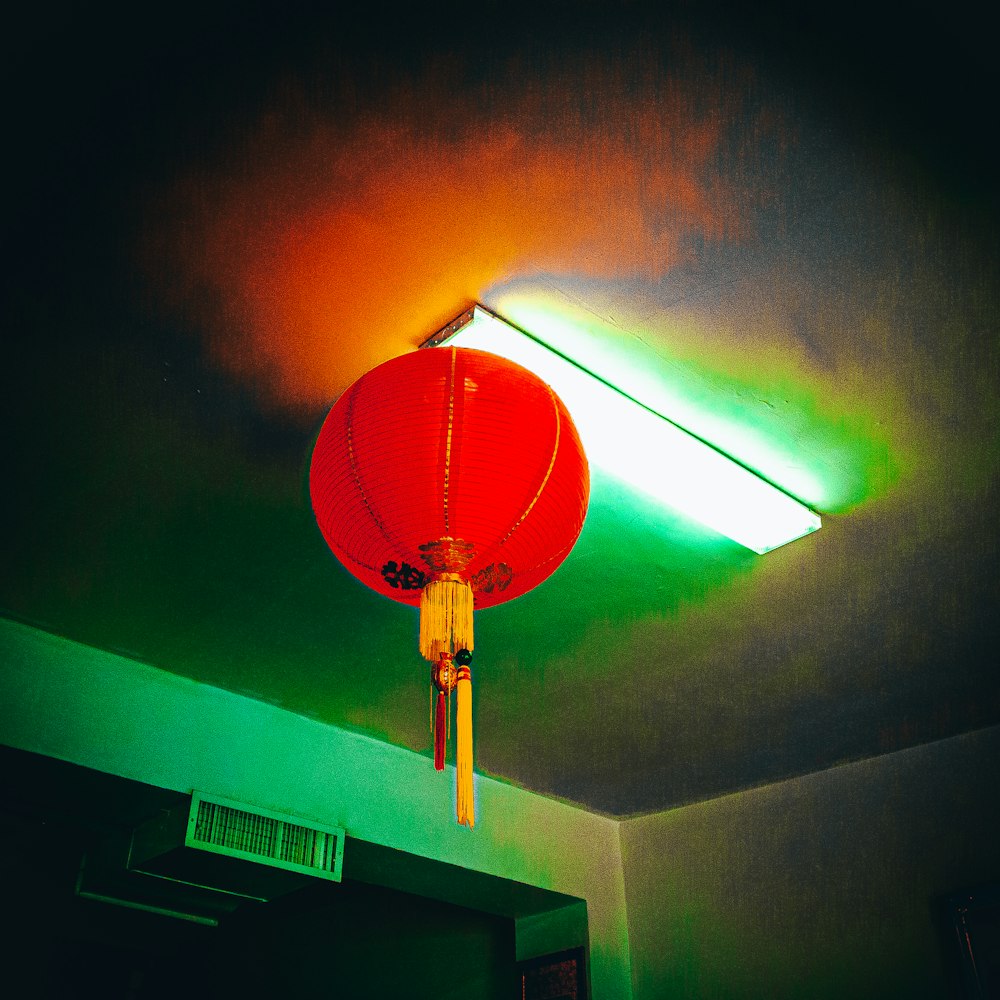 a red lamp hanging from a ceiling in a room