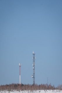 a couple of cell towers sitting in the middle of a snow covered field