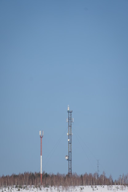 a couple of cell towers sitting in the middle of a snow covered field