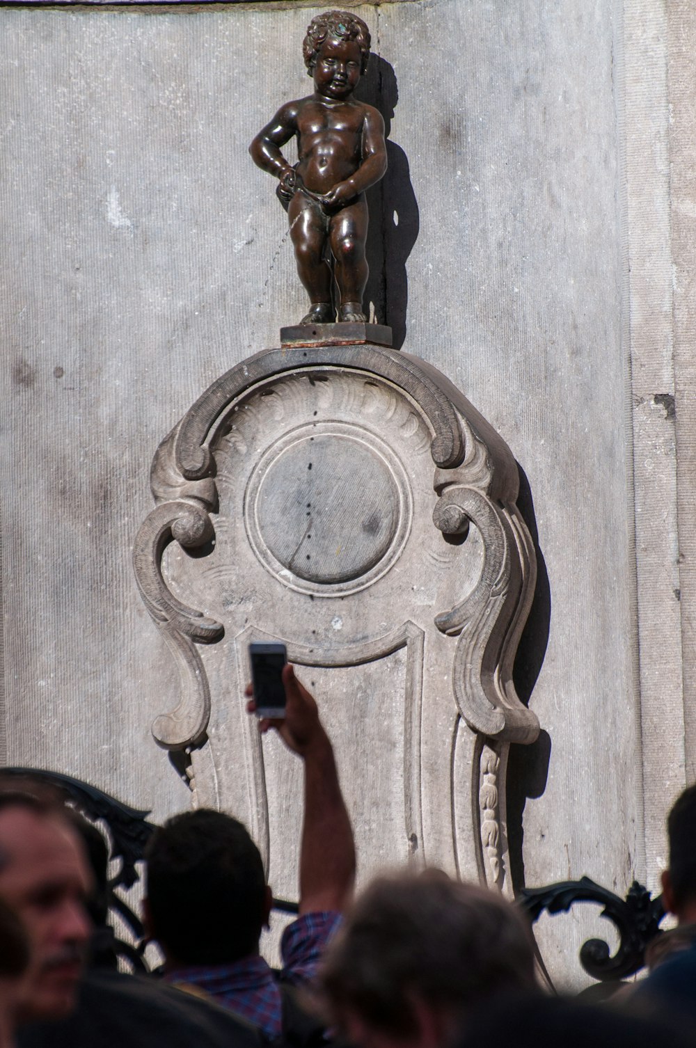 a statue of a man holding a cell phone