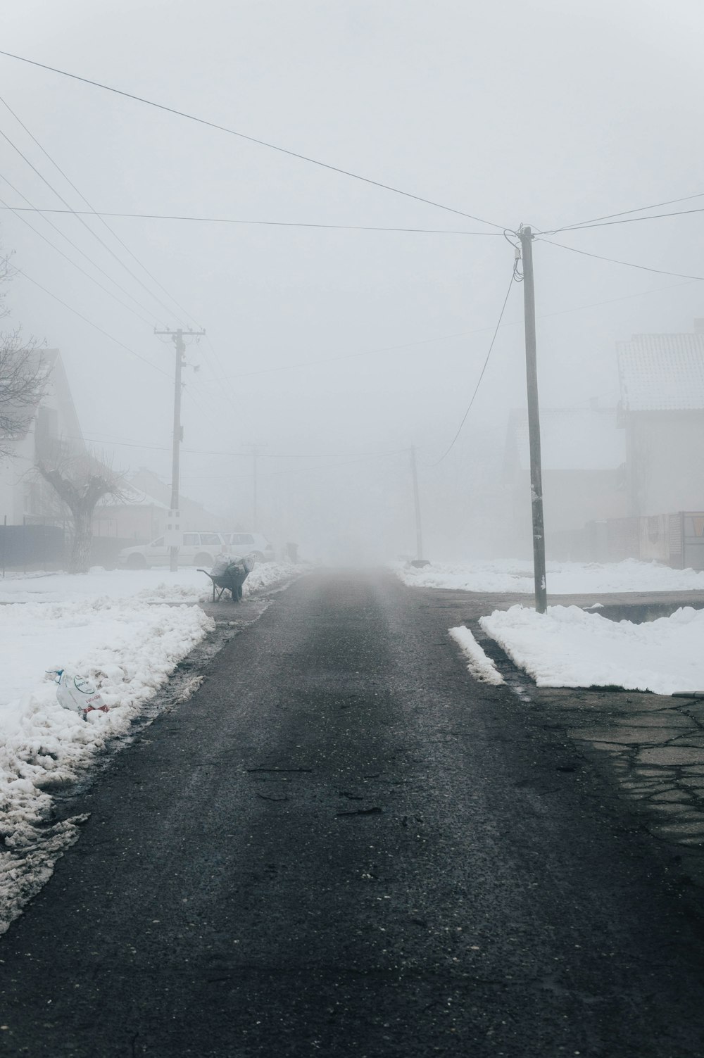 a road with snow and power lines in the background