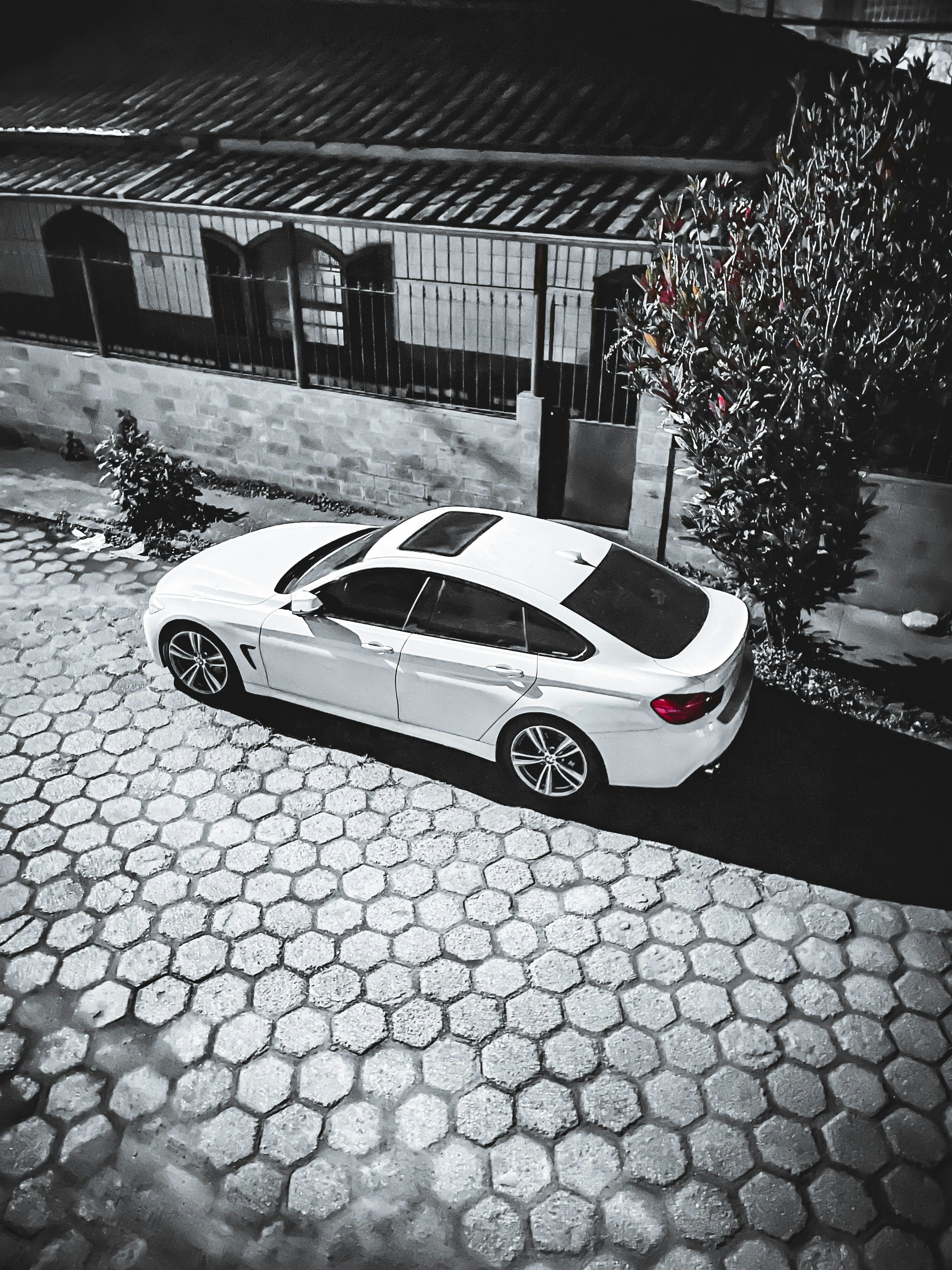 A white car parked in front of a building photo – Free Car Image on ...