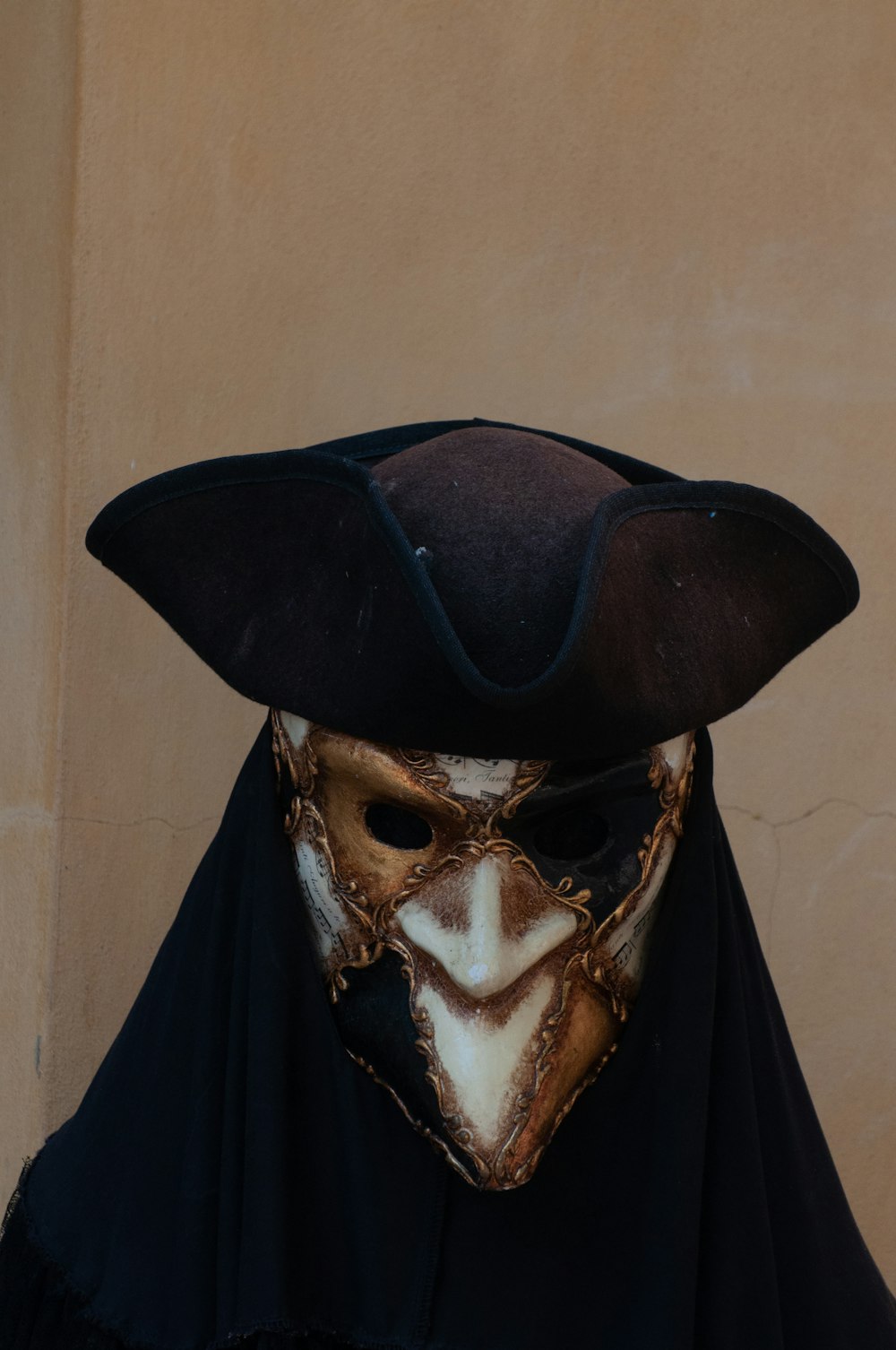 uma pessoa usando uma máscara e uma capa preta