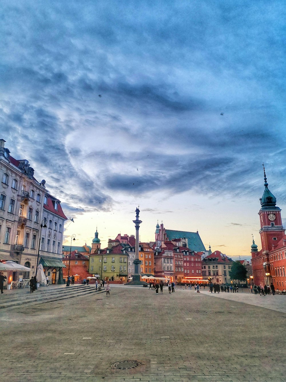 a city square with a clock tower in the background