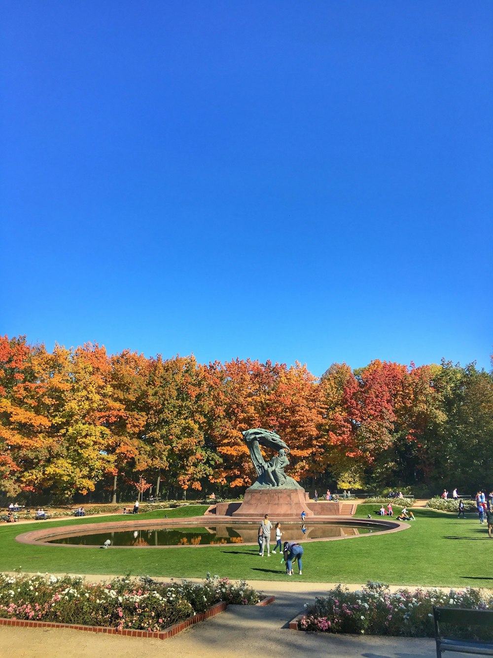 Una estatua en un parque rodeado de árboles de colores