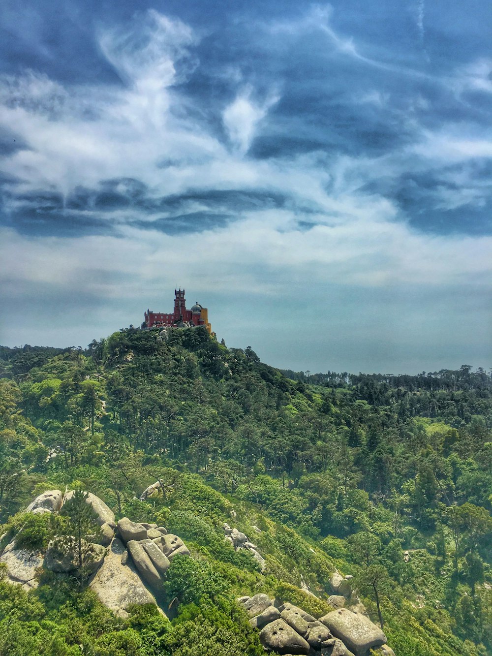 Un castillo en la cima de una colina rodeado de árboles