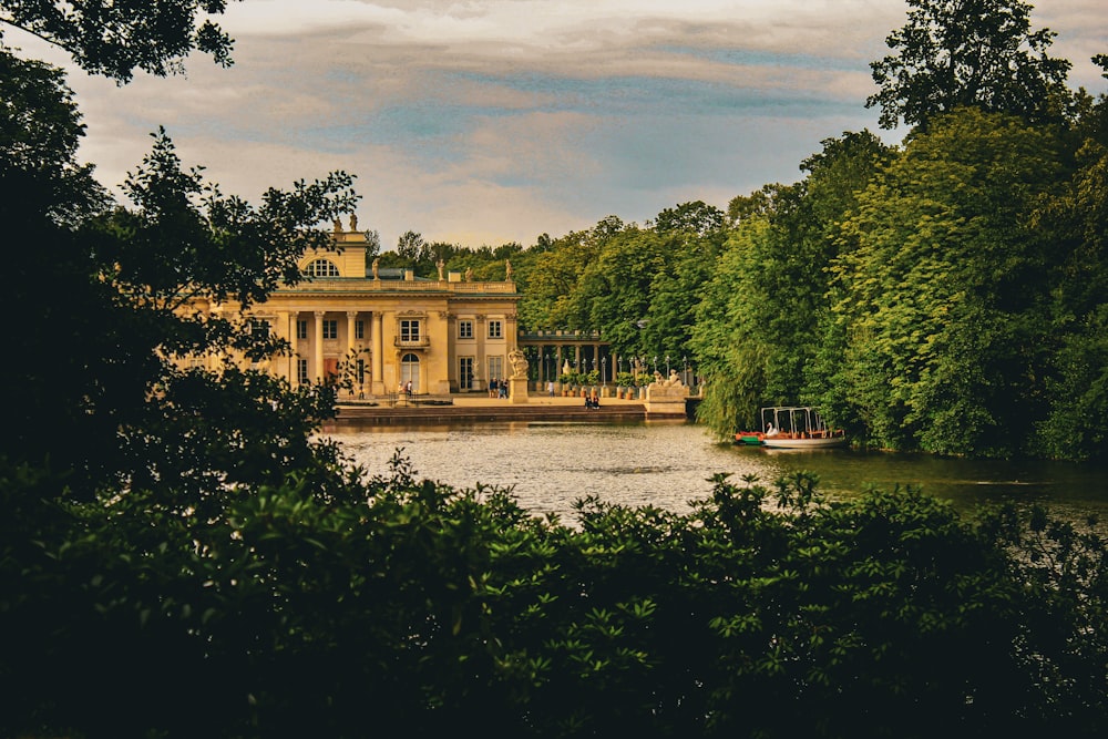 a large building sitting on top of a lake surrounded by trees