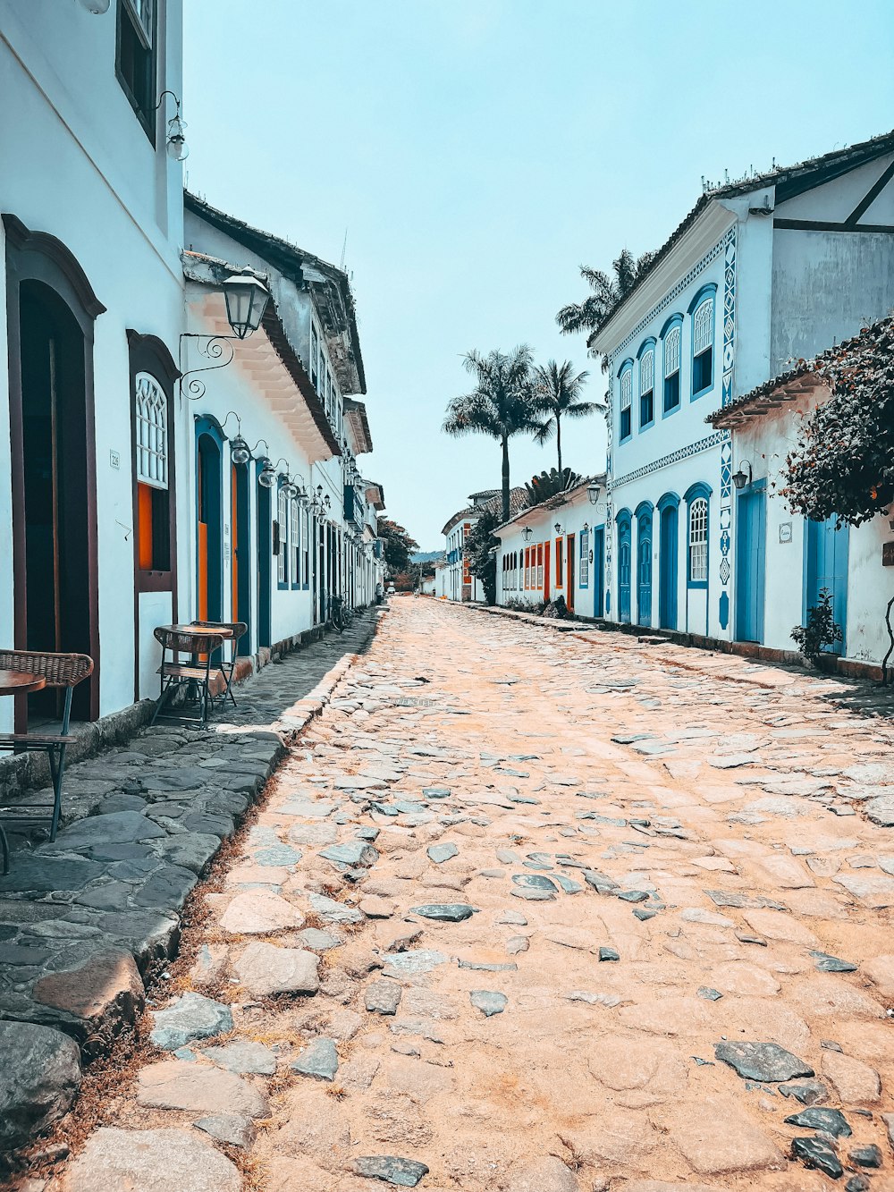 a cobblestone street lined with white buildings