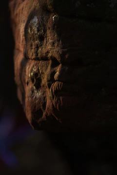 A close-up of a weathered ancient artifact illuminated softly against a dark background.