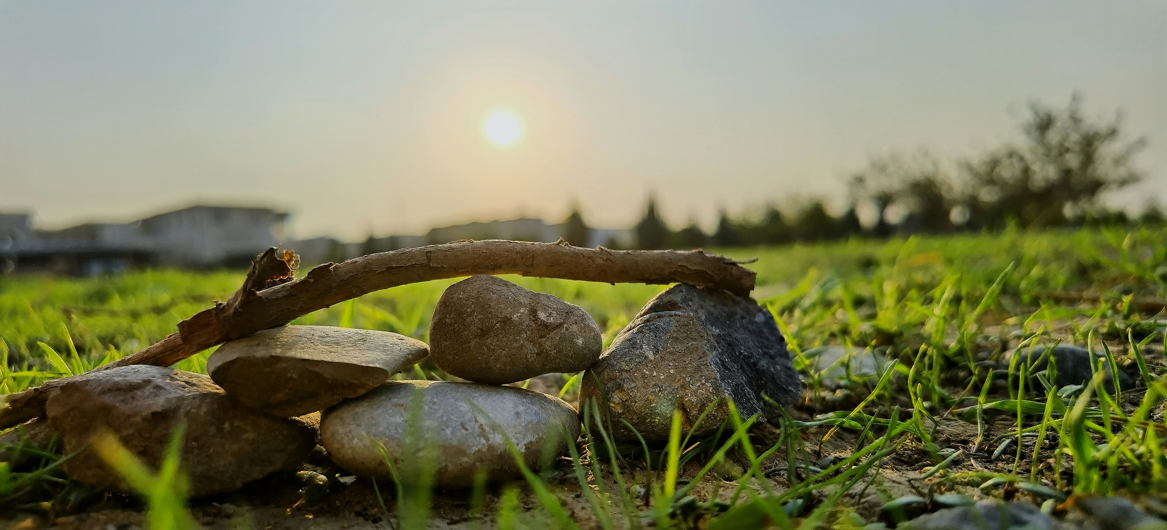 a pile of rocks sitting on top of a lush green field