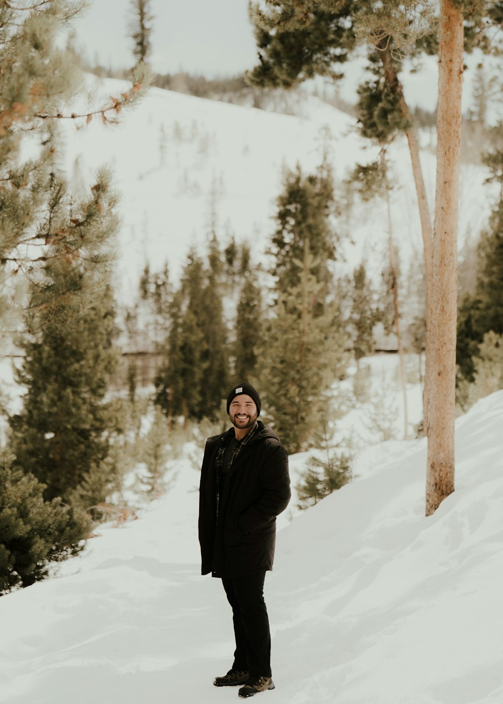 Un homme debout dans la neige devant les arbres