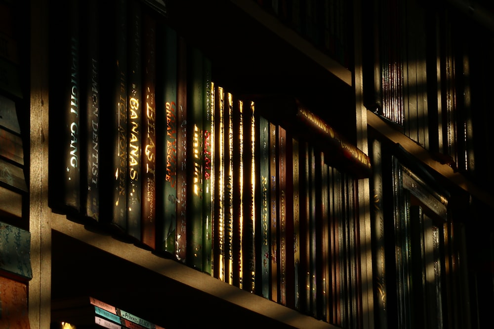 a bookshelf filled with lots of books in a dark room