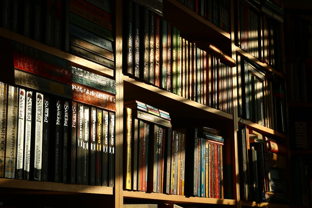 a bookshelf filled with lots of books in a room