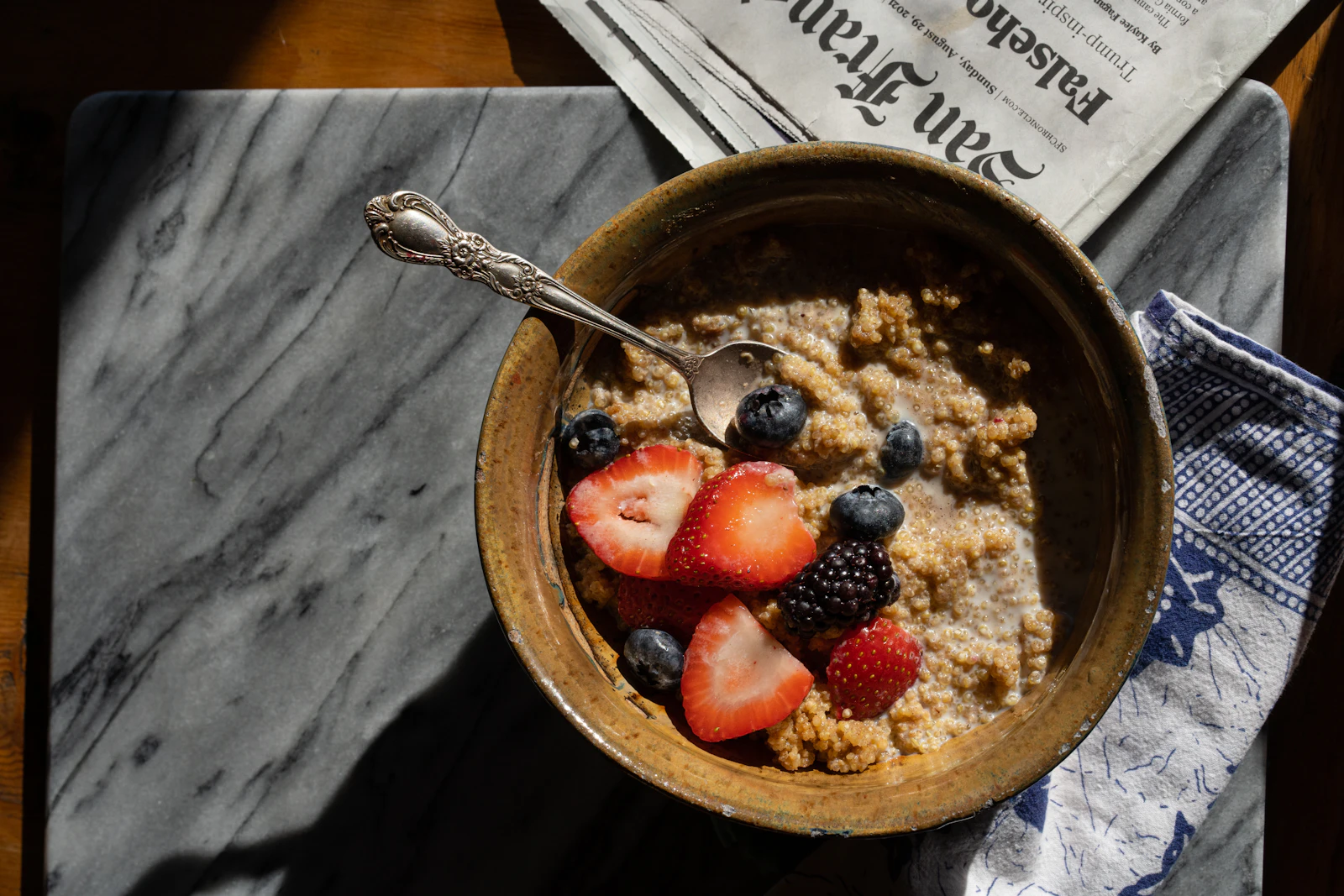 A bowl of oats topped with strawberries and blueberries