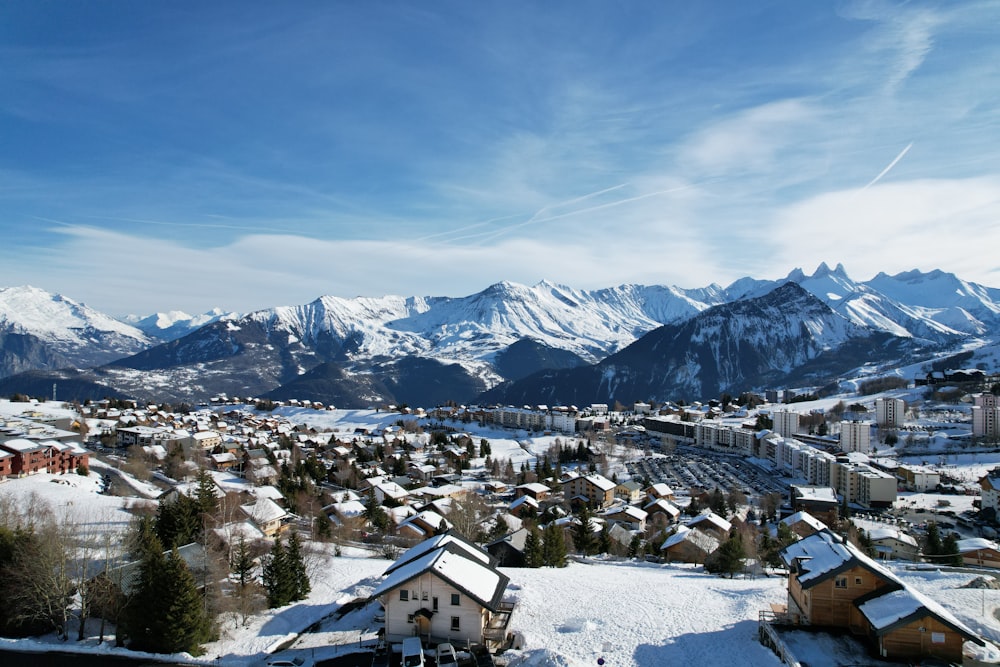 a snow covered town with mountains in the background