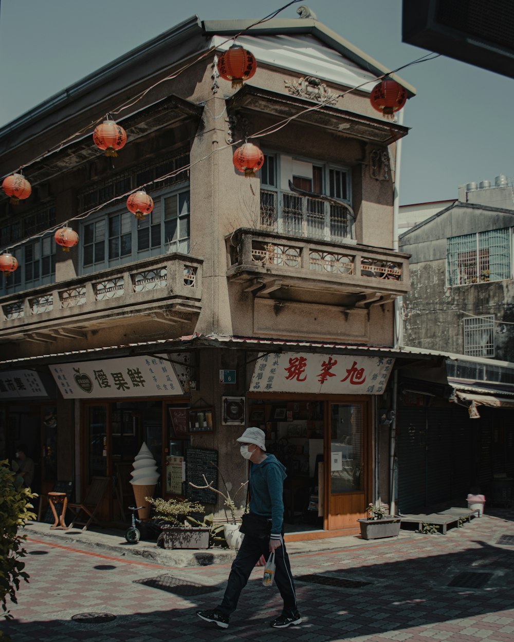 a man walking down a street in front of a building