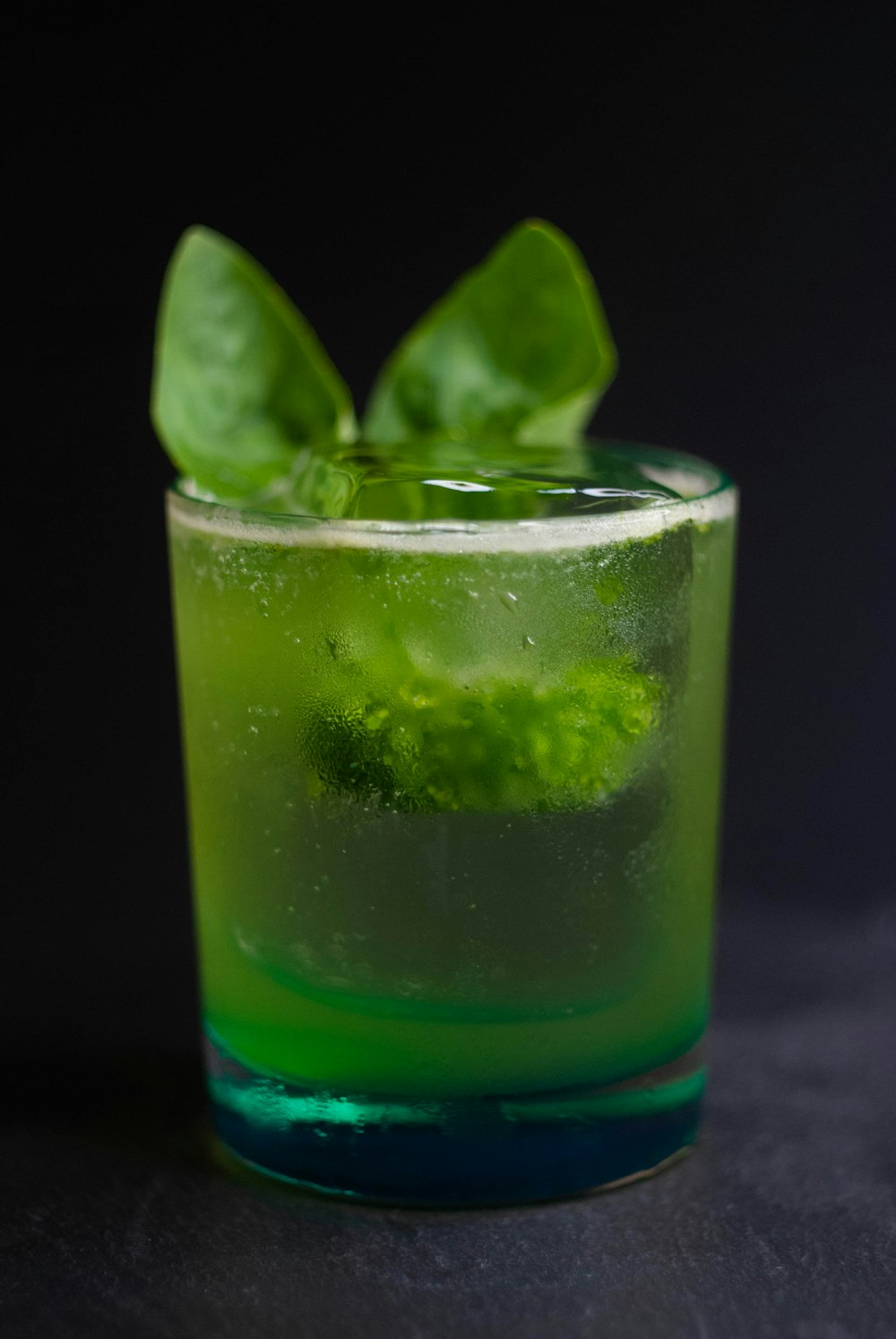 a close up of a green drink in a glass