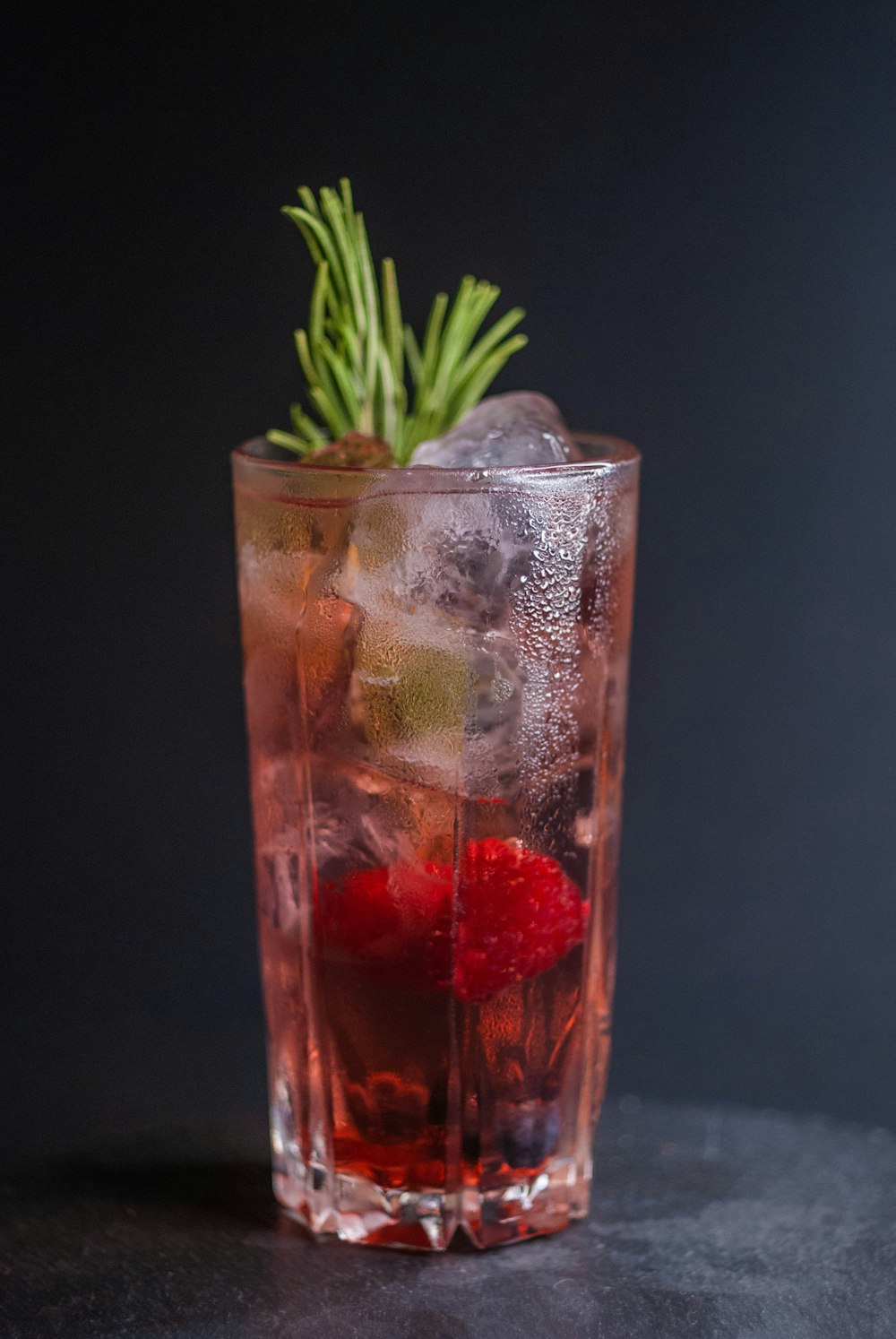 a tall glass filled with ice and fruit