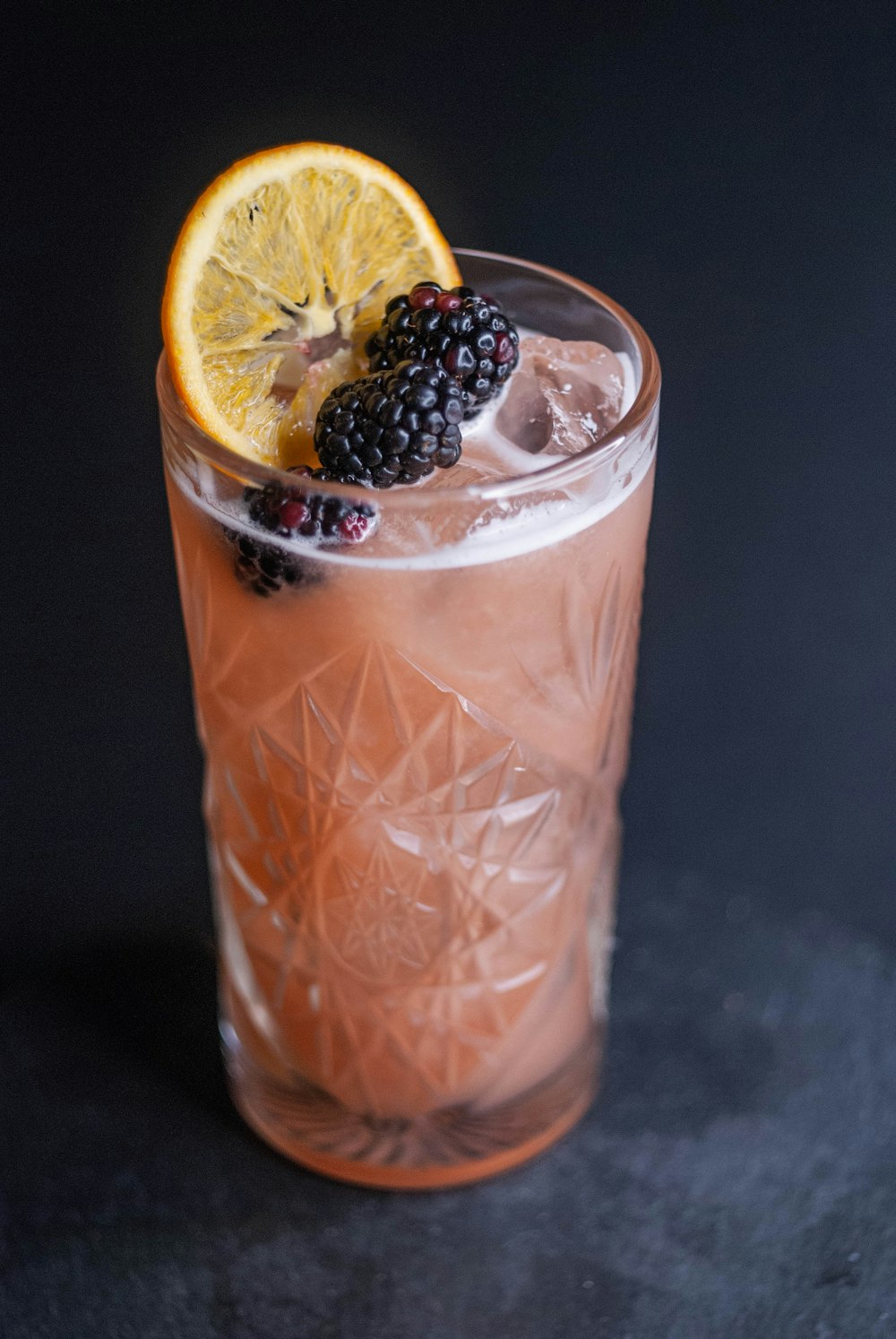 a close up of a drink with fruit on the rim