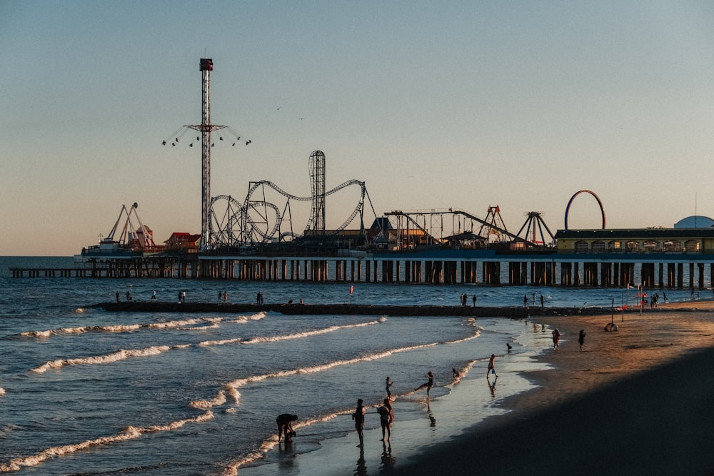 a beach with a roller coaster in the background