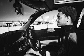 A calm and focused driving instructor guiding a student through a city street in Alanya.