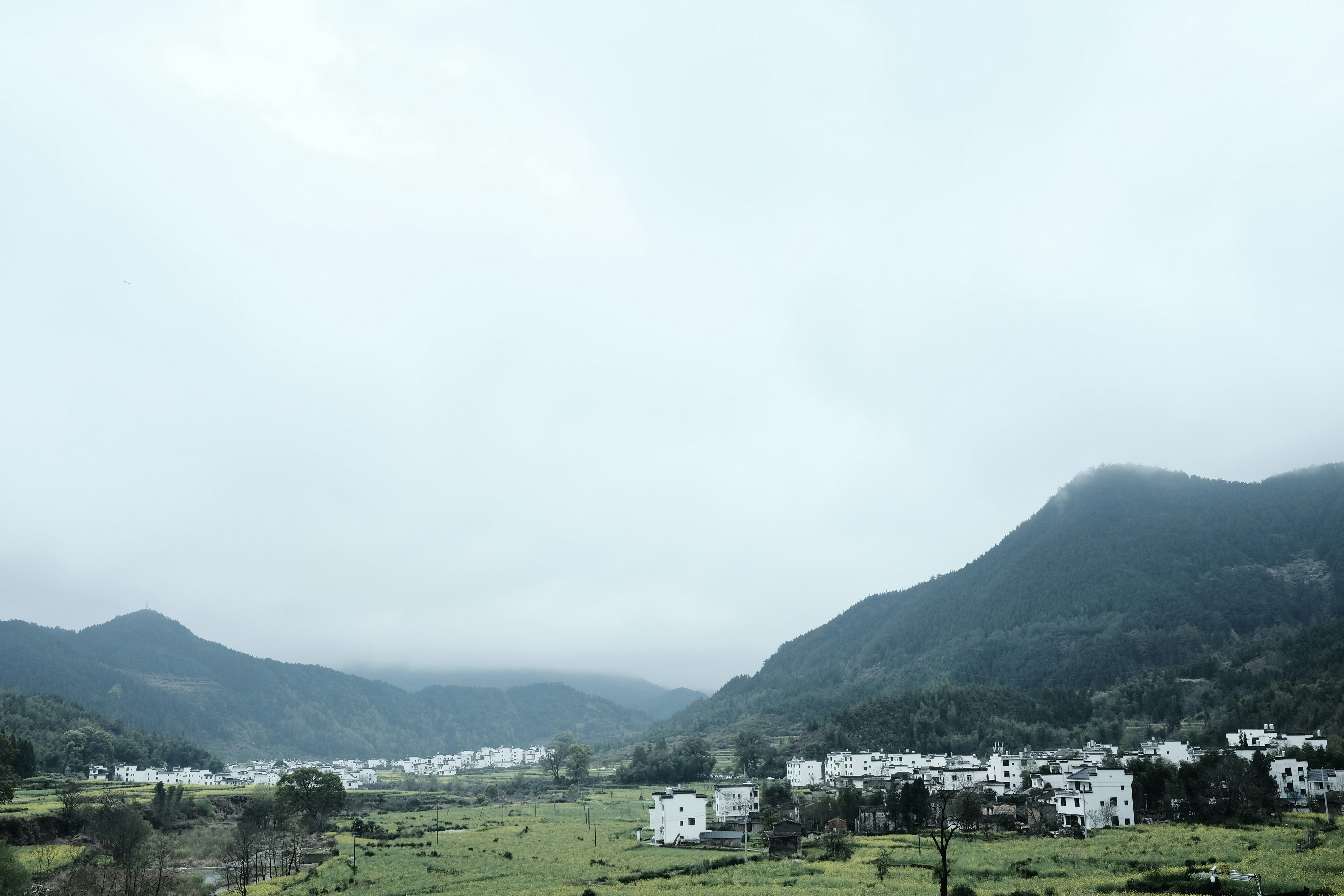a view of a town in the distance with mountains in the background