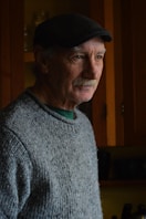 an older man wearing a hat in a kitchen