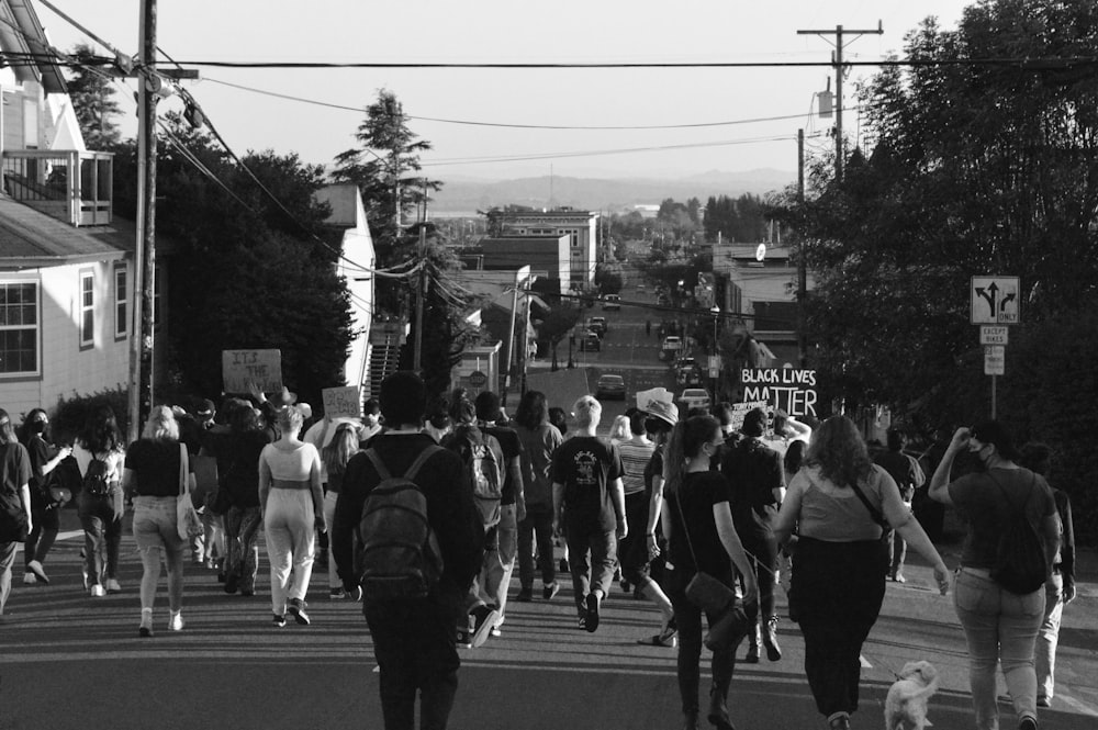 a group of people walking across a street