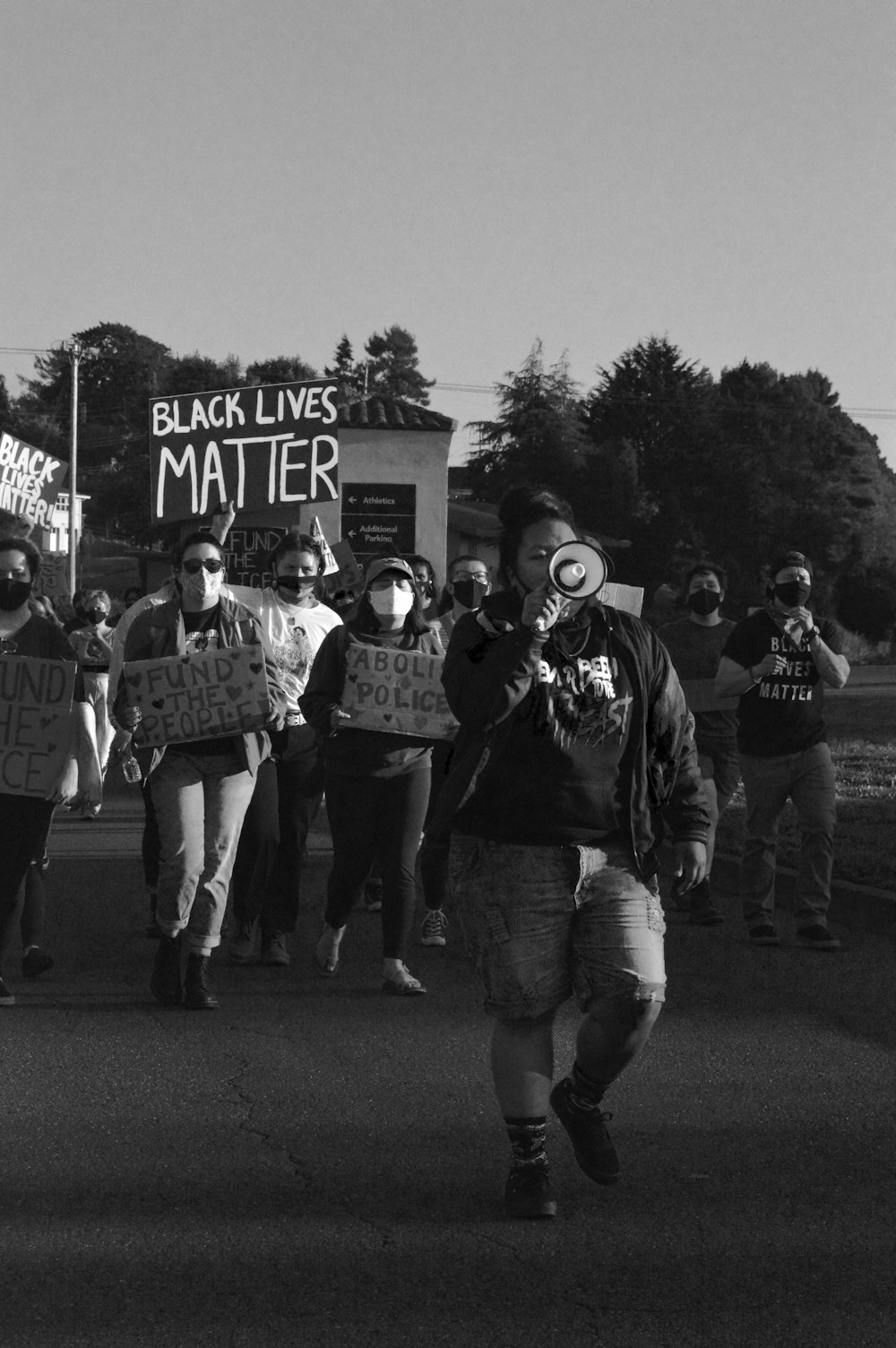 a group of people walking down a street holding signs