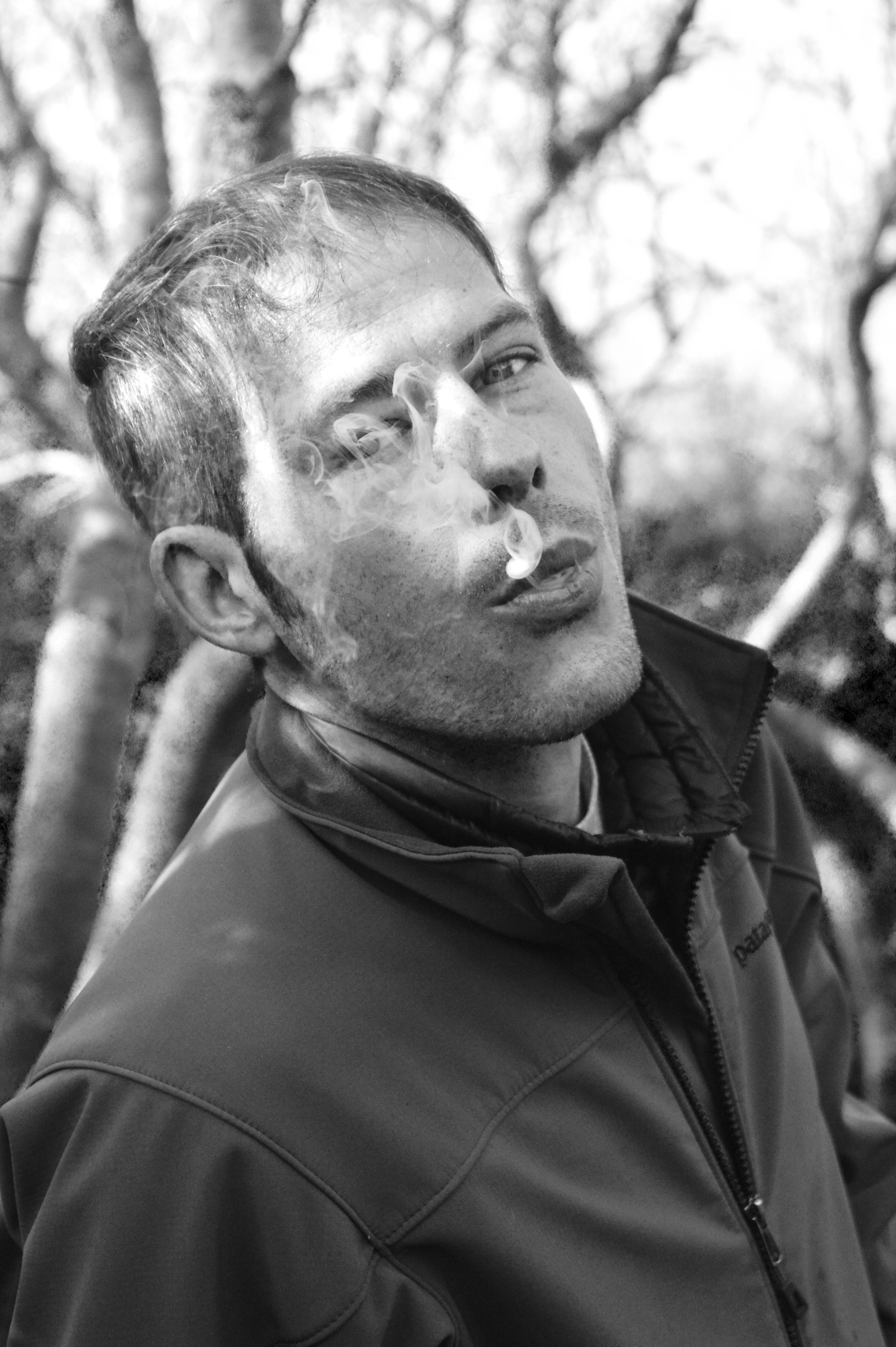 Un hombre fumando un cigarrillo en una foto en blanco y negro