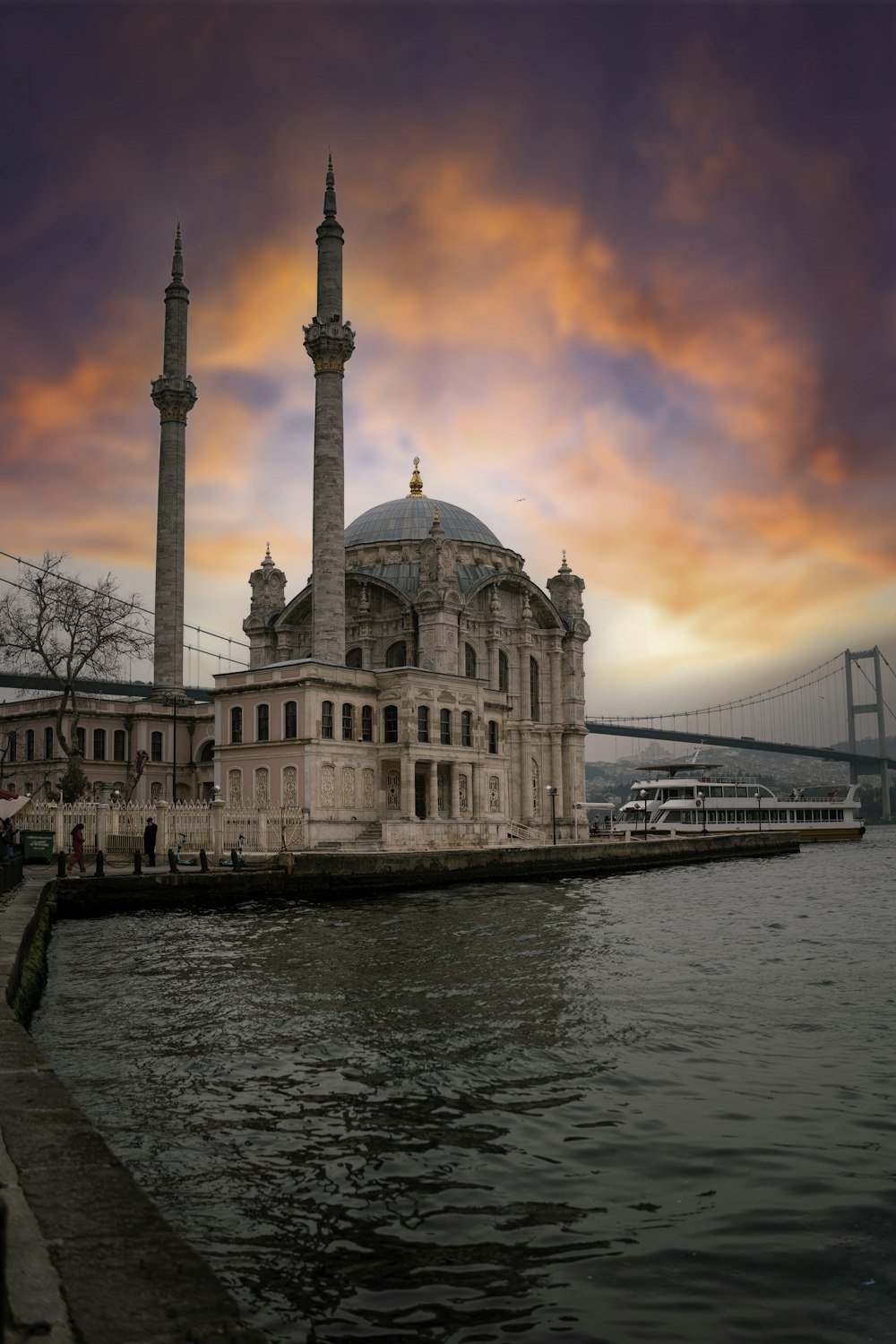 a large building sitting on top of a river next to a bridge