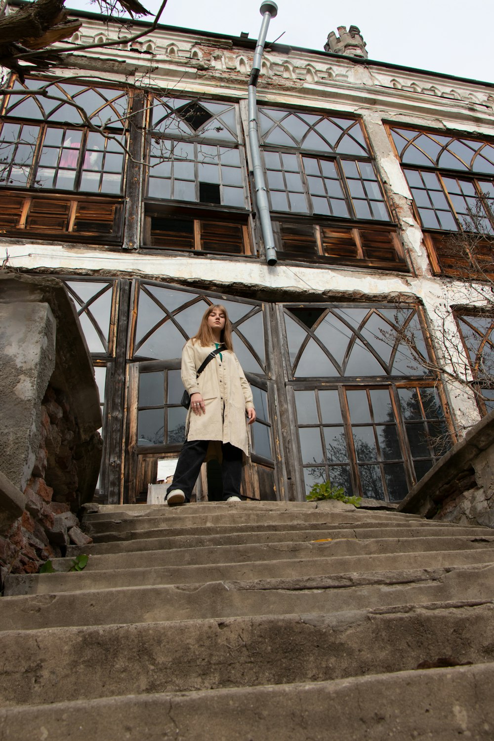 a woman standing on a set of stairs in front of a building