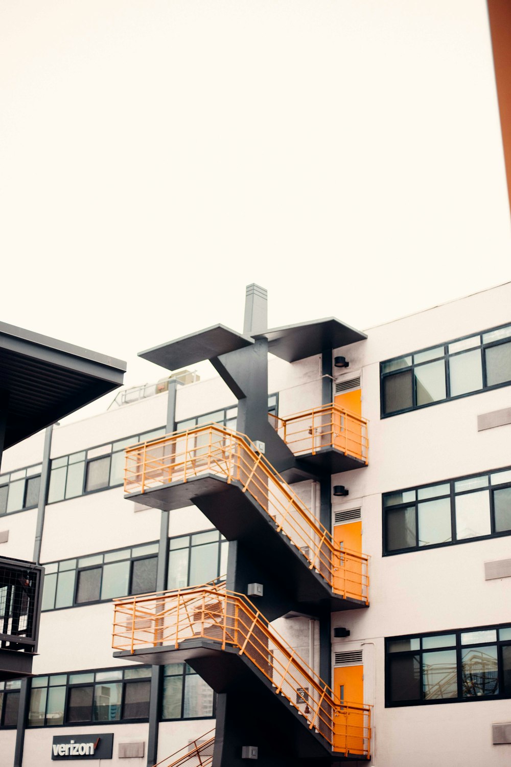 a tall building with orange balconies next to it