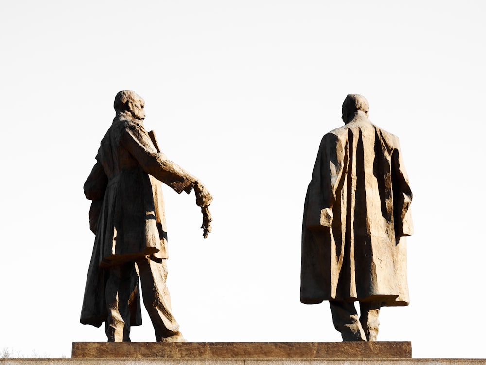 two statues of two men standing next to each other