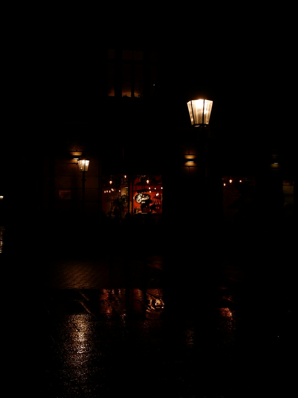 a dark street at night with a building lit up