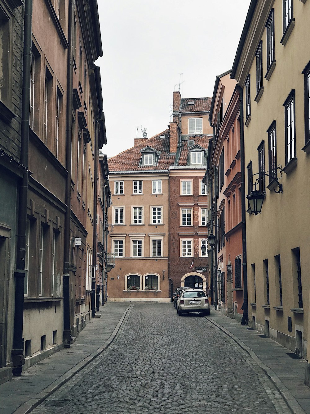 a car is parked on a cobblestone street