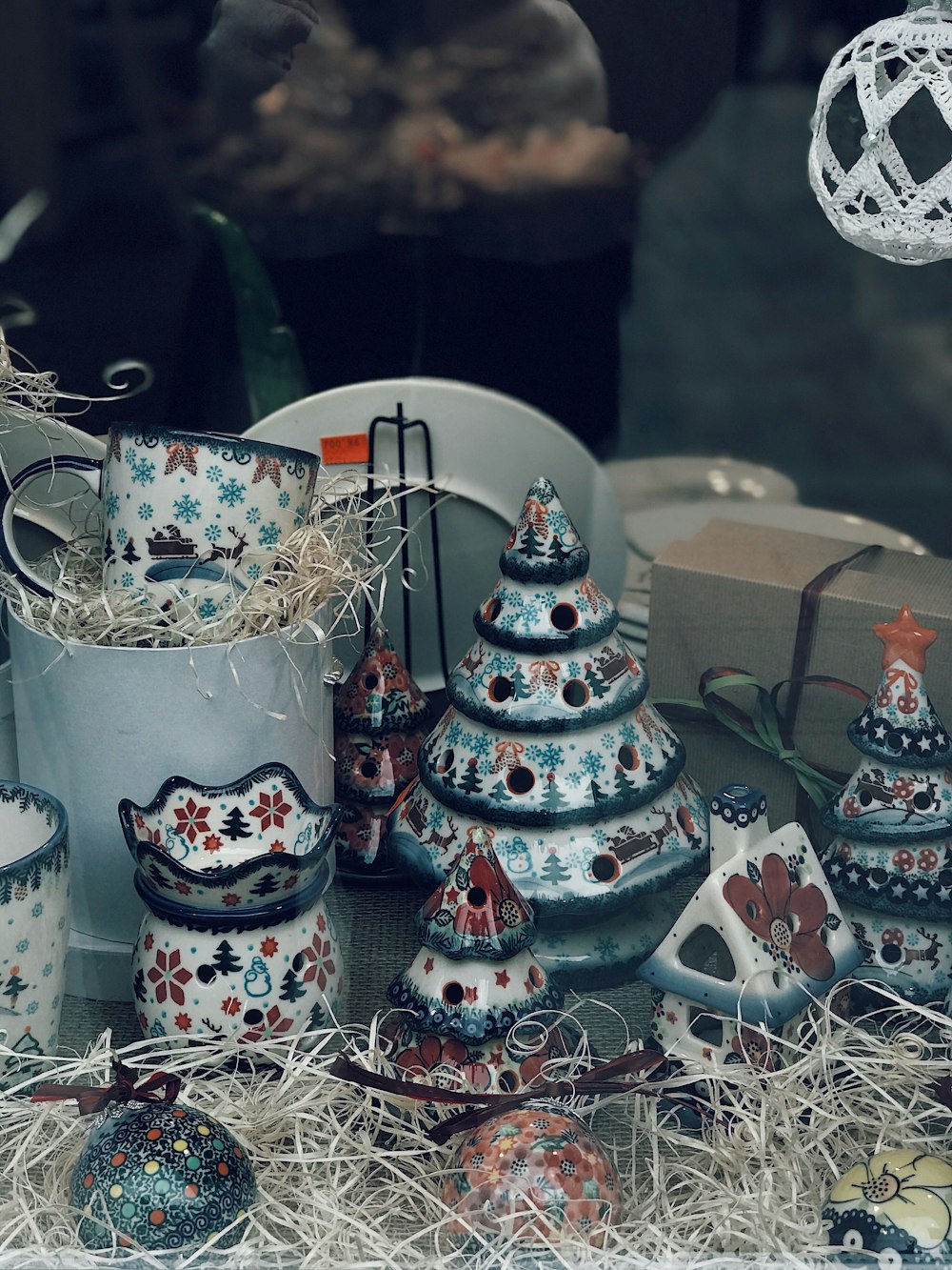 a display of ceramic christmas trees in a store window