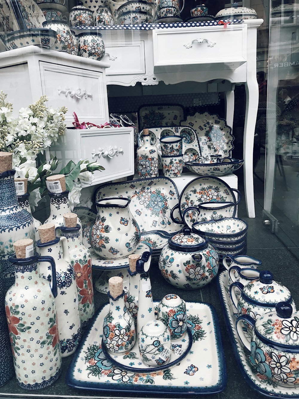 a collection of vases and dishes on display in a store window